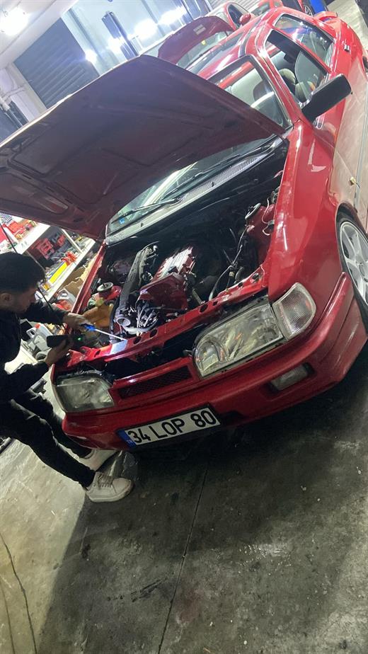 Ford Sierra’nın ön takımı sökülmüş, usta motor bölmesinde çalışıyor