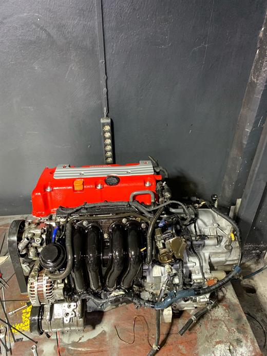 Honda K20 motoru revizyon için sökülmüş, kırmızı Type-R subap kapağı ile şanzıman birlikte