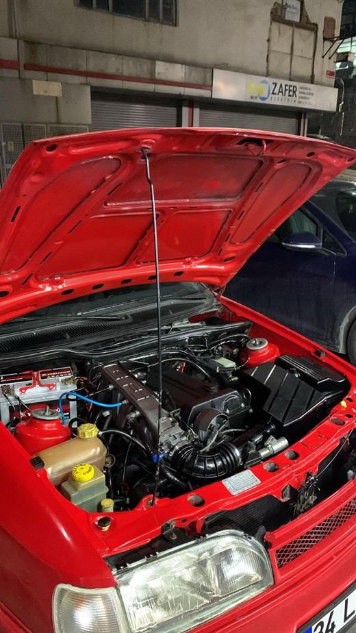 Kırmızı retro aracın motor bölmesinde turbo, emme hattı ve genişletme kabı detayı