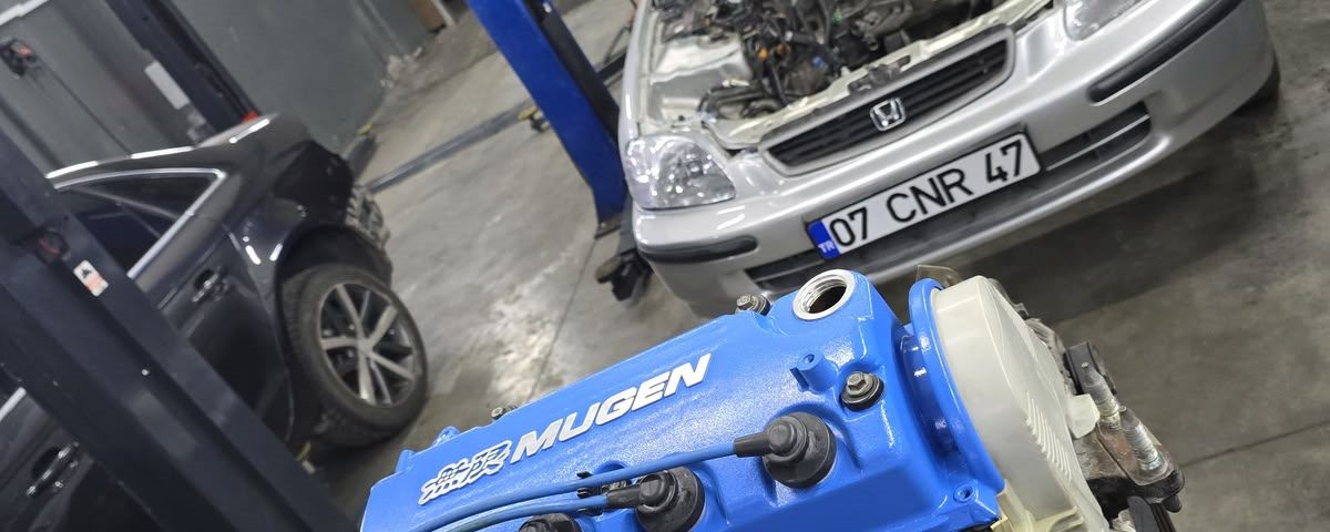 Honda Civic EK kasa ve önünde Mugen subap kapaklı B16 motor, garaj lift alanında